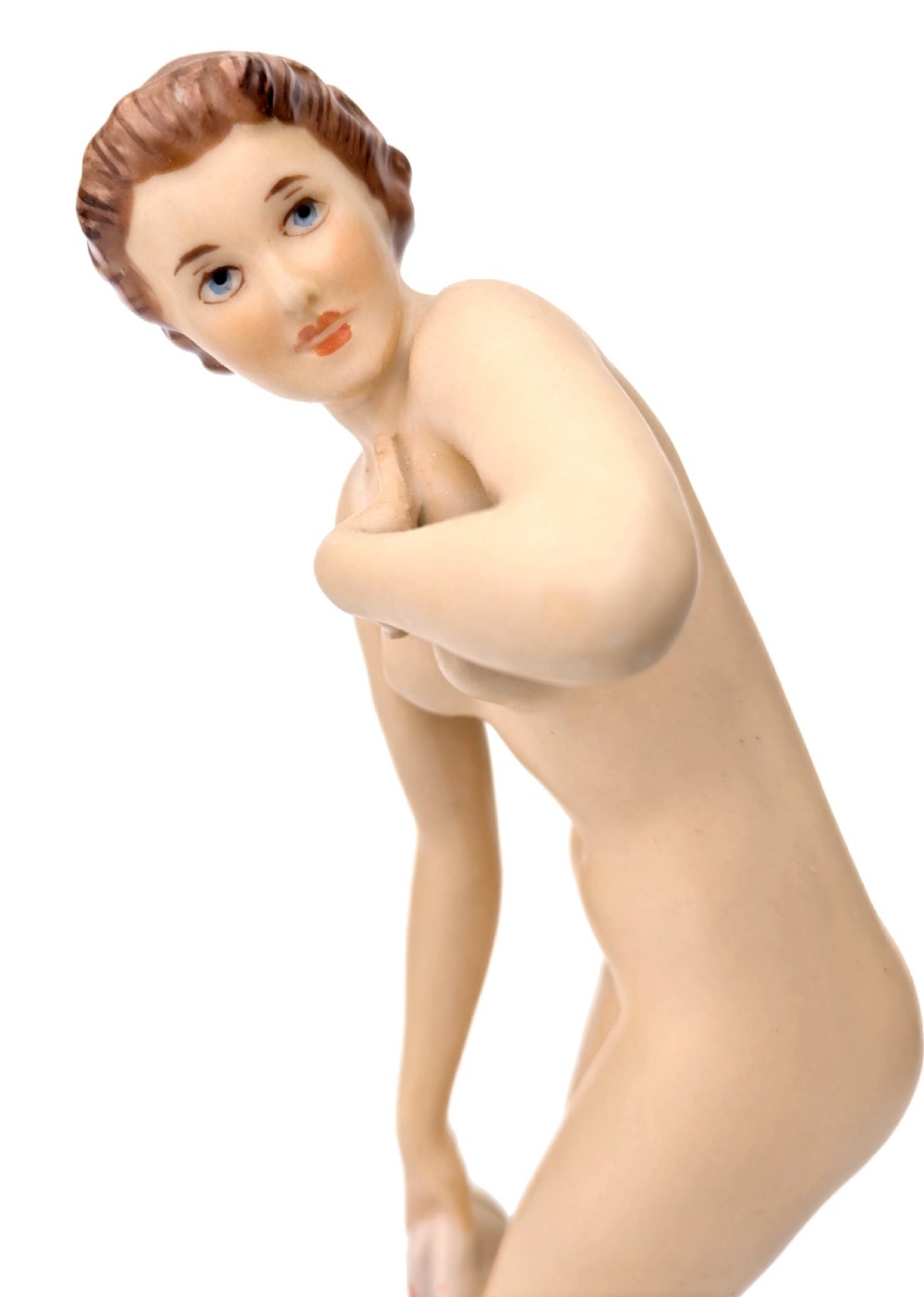 An Art Deco glazed porcelain figurine depicting a standing nude female figure holding a soft pink patterned drape on a rounded cream base. View VIII