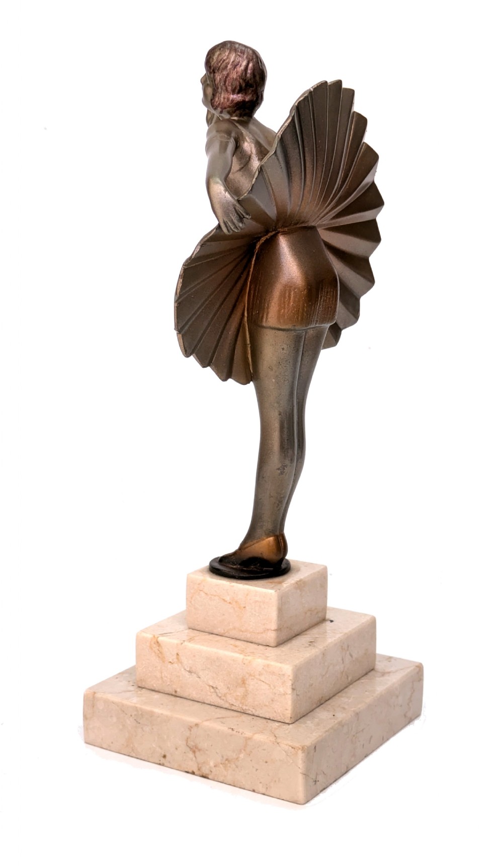 An Art Deco spelter sculpture depicting a female dancer in a stylized fan dress, standing on a three-tiered beige marble plinth. View III