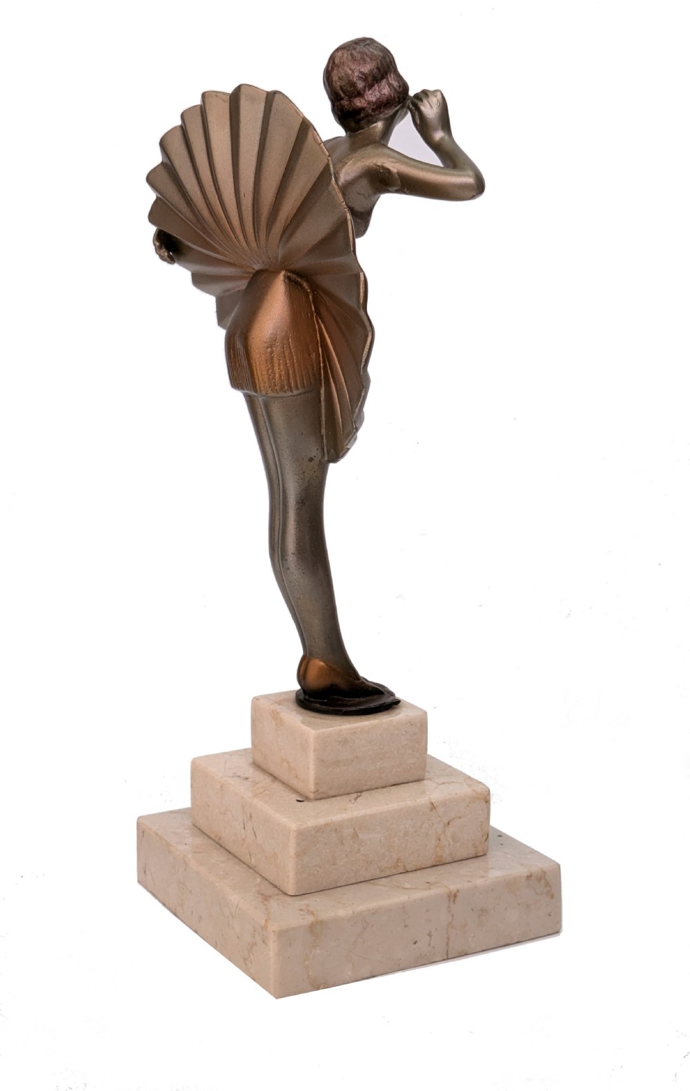 An Art Deco spelter sculpture depicting a female dancer in a stylized fan dress, standing on a three-tiered beige marble plinth. View V