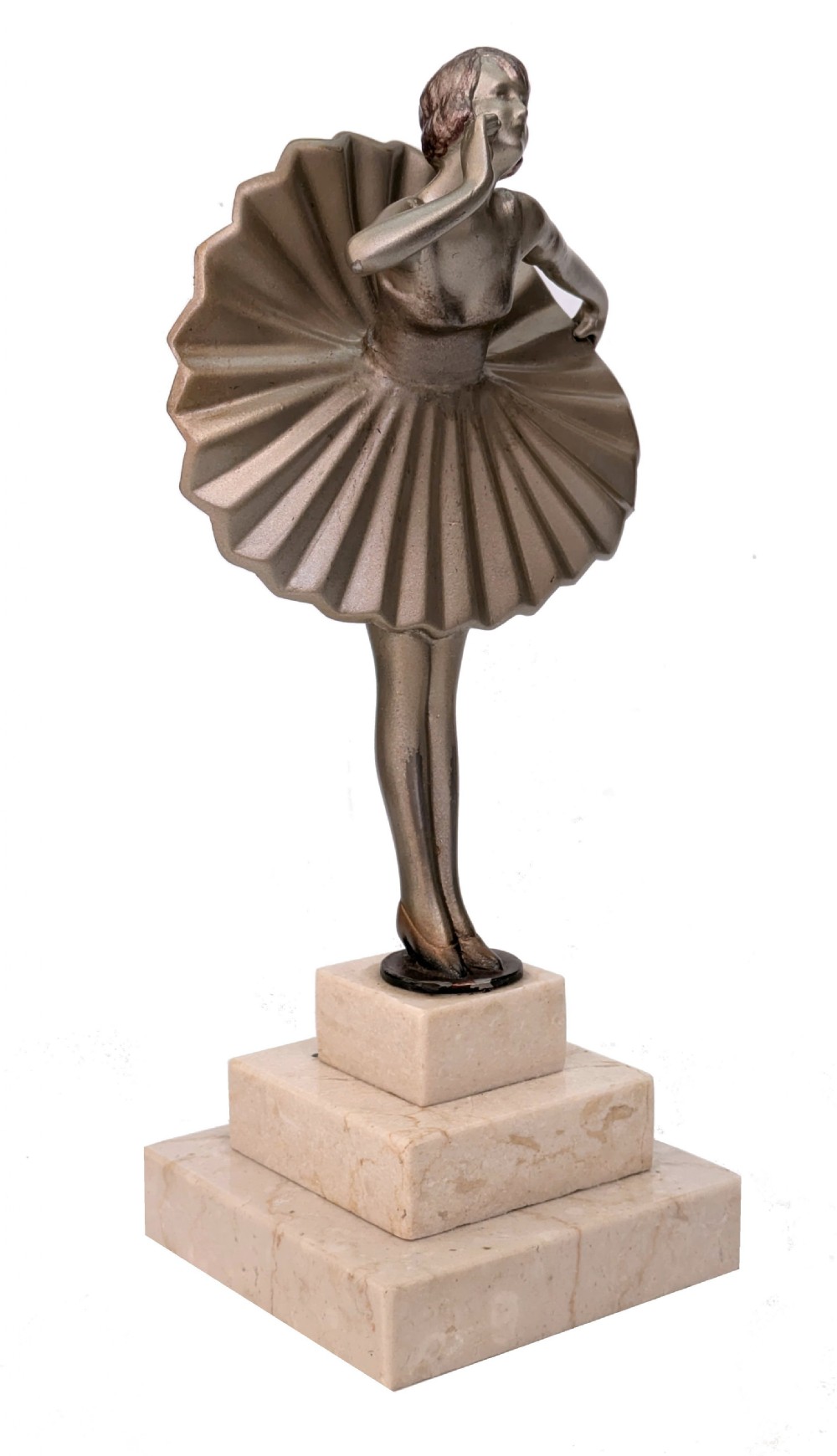 An Art Deco spelter sculpture depicting a female dancer in a stylized fan dress, standing on a three-tiered beige marble plinth. View VI