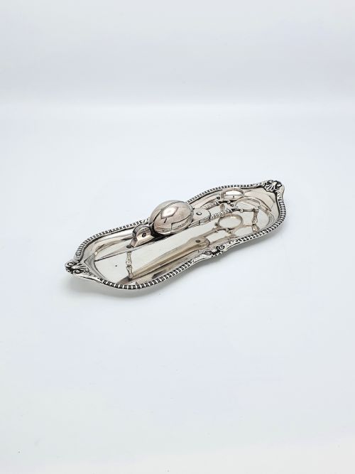 fig 1. A Victorian silver-plated candle snuffer with scissor trimmers resting on an elongated tray with gadrooned borders.