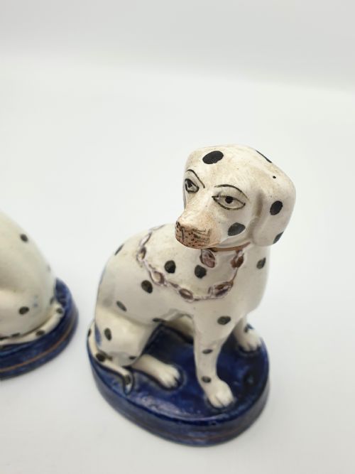 fig 1. A pair of late Victorian Staffordshire earthenware figures depicting seated Dalmatians with hand-painted black spots on cobalt blue bases.