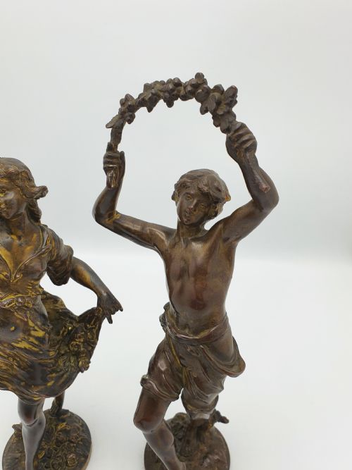 fig 2. A pair of dark patinated bronze figurines depicting male and female harvest dancers holding floral garlands.