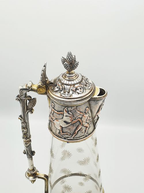fig 1. A tall Victorian silver-plated and etched glass claret jug featuring classical reliefs, a Greek key border, and star-cut engravings.