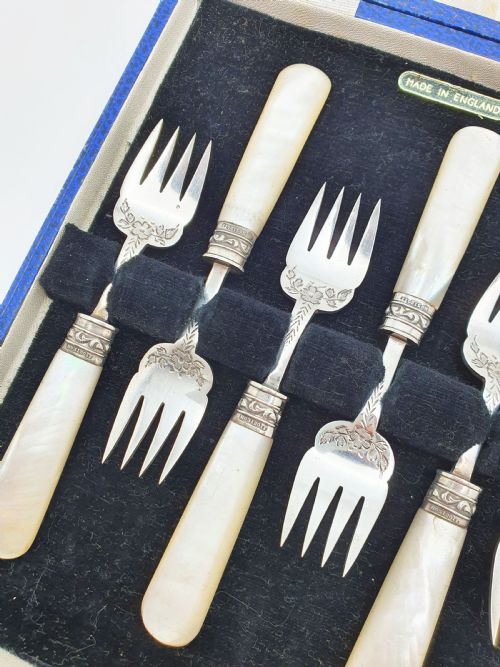 fig 1. A cased set of six Victorian hors doeuvres forks featuring mother-of-pearl handles and engraved silver-plated tines, presented in a blue fabric-lined box.