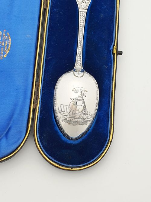 fig 1. An 1877 Victorian sterling silver presentation spoon with an engraved stag motif inside an open blue velvet presentation box.