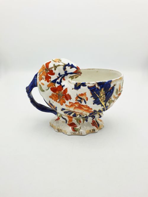 fig 1. A late Victorian Ridgways china spoon warmer in the shape of a nautilus shell with cobalt blue, terracotta orange floral details, and gilded trim.