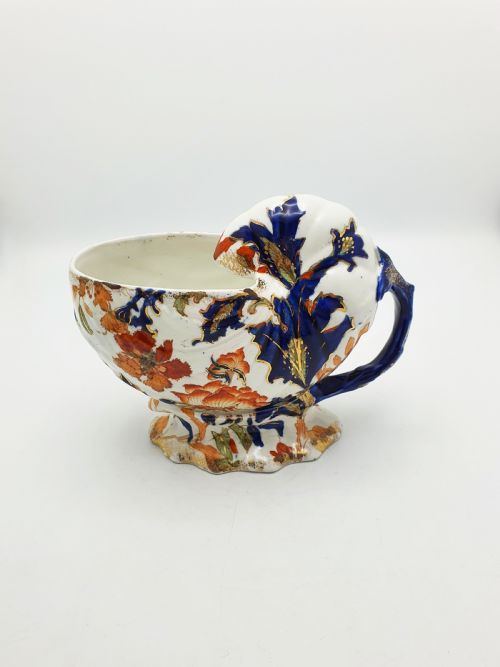 fig 3. A late Victorian Ridgways china spoon warmer in the shape of a nautilus shell with cobalt blue, terracotta orange floral details, and gilded trim.