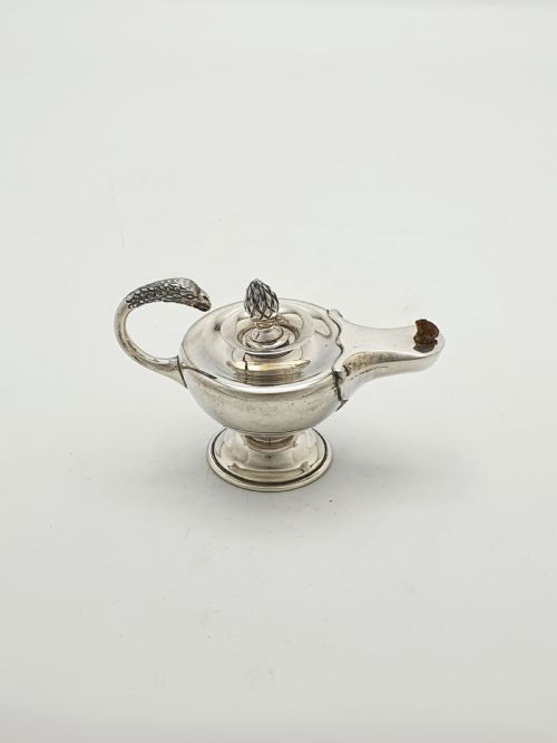 fig 1. A sterling silver table lighter crafted in the shape of a classical Roman oil lamp with a serpent-shaped handle and pedestal foot.