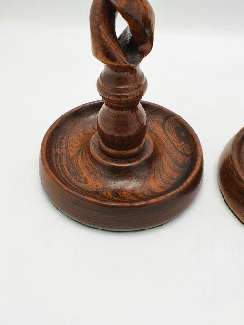 fig 1. A pair of dark oak candlesticks featuring open barley twist stems and brass sconces atop round dished bases.
