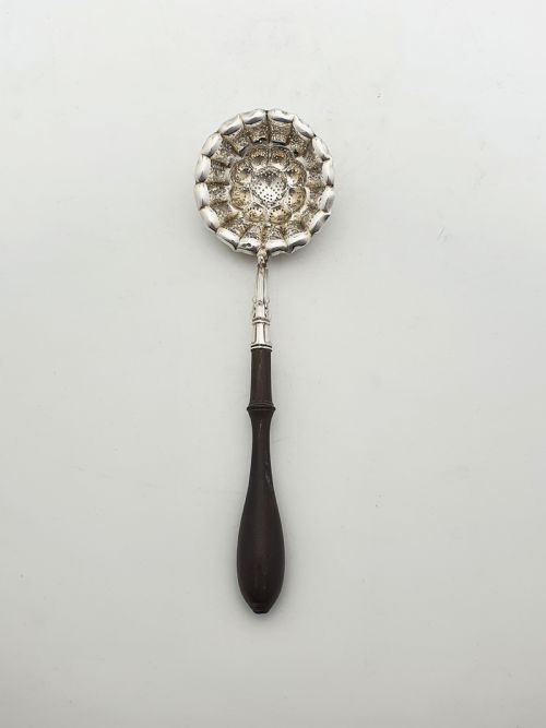 fig 2. A late nineteenth-century Continental silver tea strainer featuring a fluted pierced bowl attached to a dark turned wooden handle.