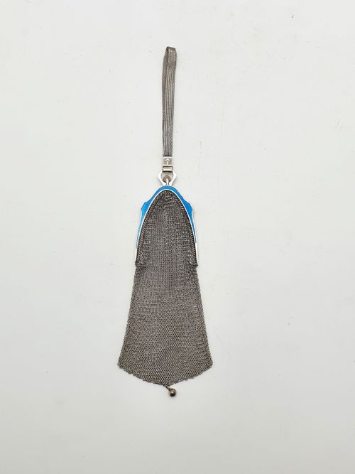 fig 1. An antique silver mesh purse featuring a blue guilloche enamel top frame, a woven silver strap, and a hanging metal drop.