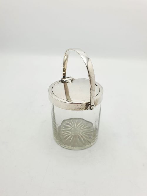 fig 1. An antique cut glass condiment jar featuring a hallmarked sterling silver rim, swing handle, and hinged lid.