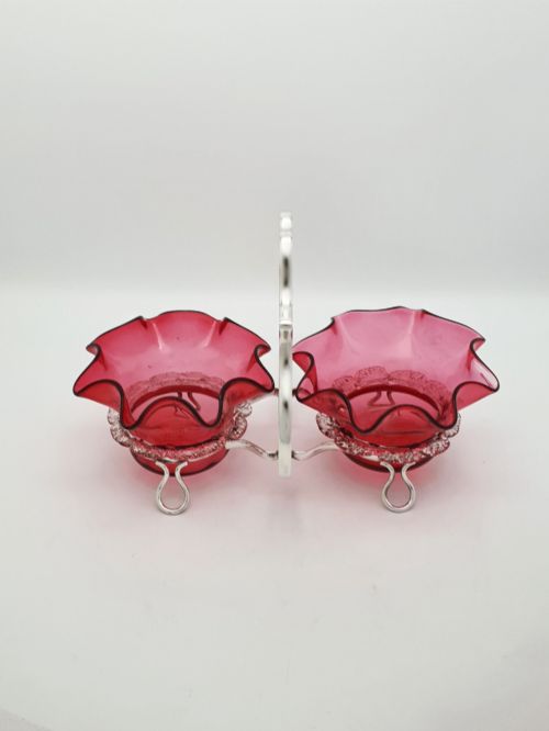 fig 1. An Edwardian twin cranberry glass preserve dish set with crimped rims held in a silver-plated wireframe stand with a central handle.