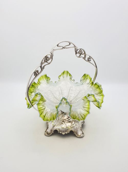 fig 1. An Art Nouveau silver-plated centrepiece frame with an arched handle holding a frilled green-rimmed vaseline glass dish with a crackle texture.