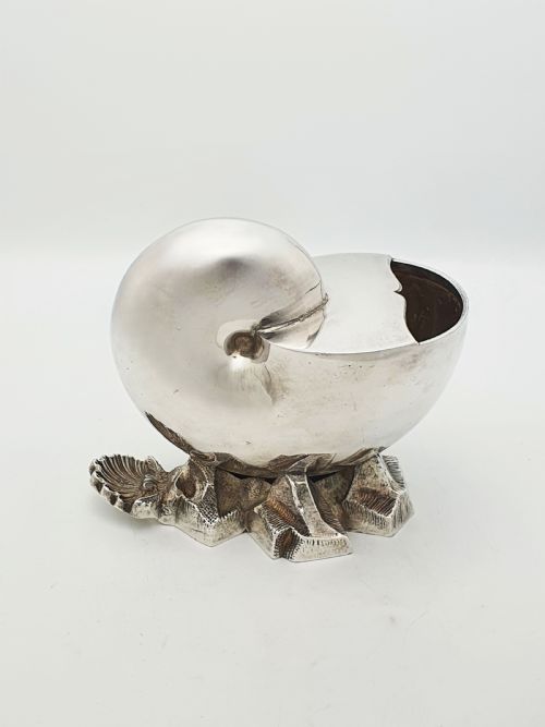 fig 1. A Victorian silver-plated spoon warmer designed in the form of a nautilus shell mounted on a textured rocky base.
