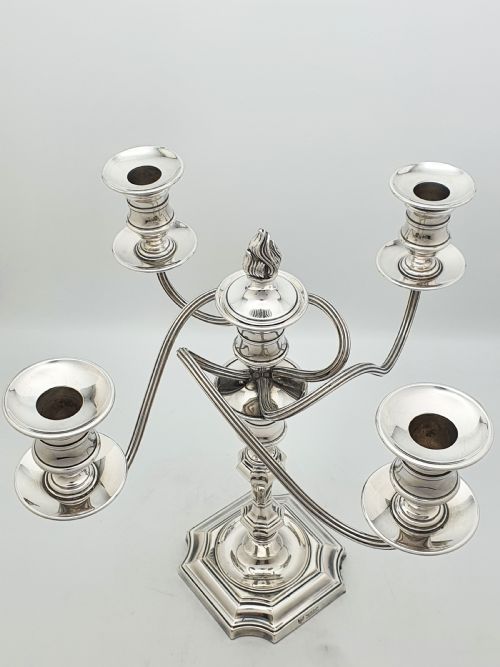 fig 1. An Edwardian silver-plated five-light candelabrum featuring curved scrolling arms, urn-form sconces, a removable flame finial, and a stepped square base.