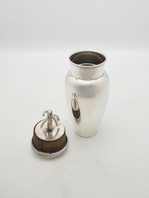 fig 1. A silver-plated Art Deco bachelor cocktail shaker featuring a baluster body, milled collar, and a domed cap.
