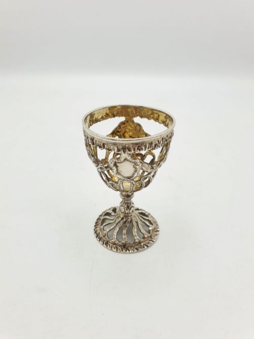 fig 1. An Edwardian sterling silver egg cup featuring openwork lattice carving, a gilded interior wash, and a footed pedestal base.