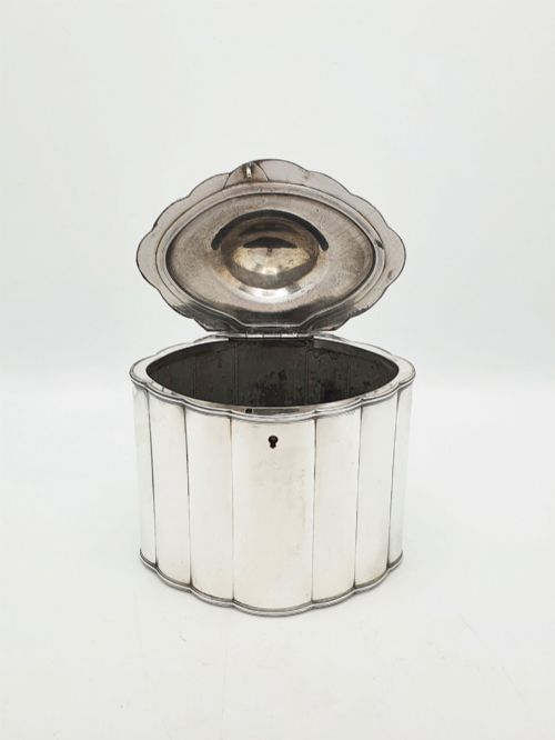 fig 1. A lobed Georgian Sheffield plated tea caddy featuring vertical fluting, a central keyhole, and a domed lid topped with an urn finial.