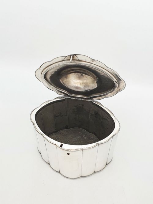 fig 2. A lobed Georgian Sheffield plated tea caddy featuring vertical fluting, a central keyhole, and a domed lid topped with an urn finial.