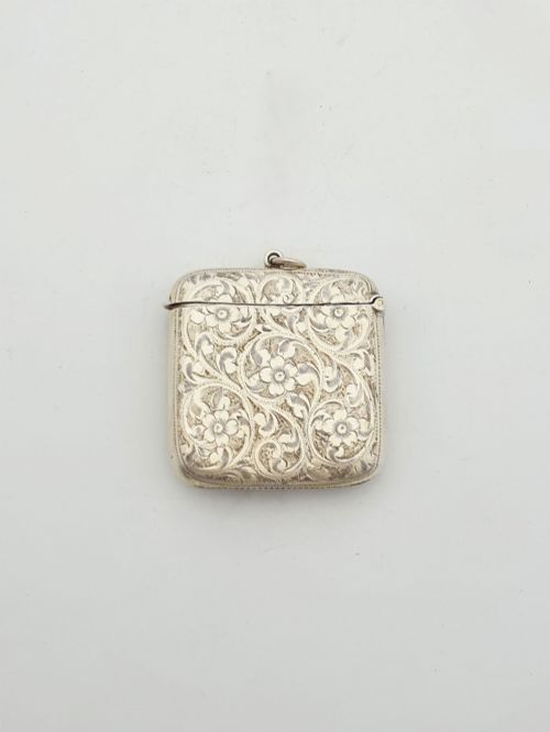 fig 2. An open Edwardian sterling silver vesta case displaying an engraved hinged lid and two interior oval photo frame apertures.