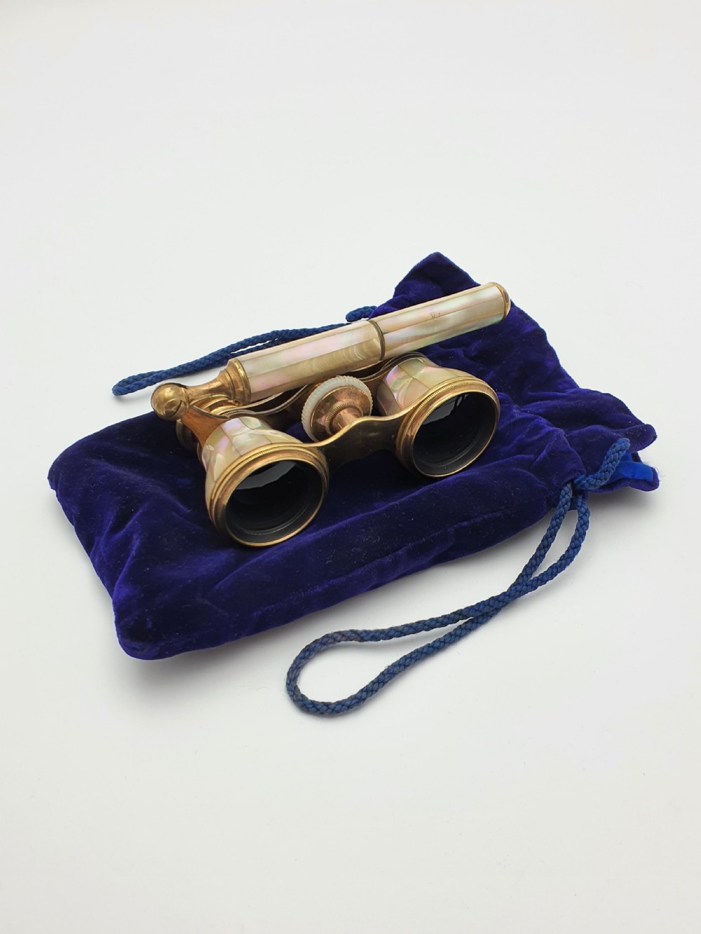 Victorian brass opera glasses featuring iridescent mother of pearl panels on the barrels and an extendable handle.