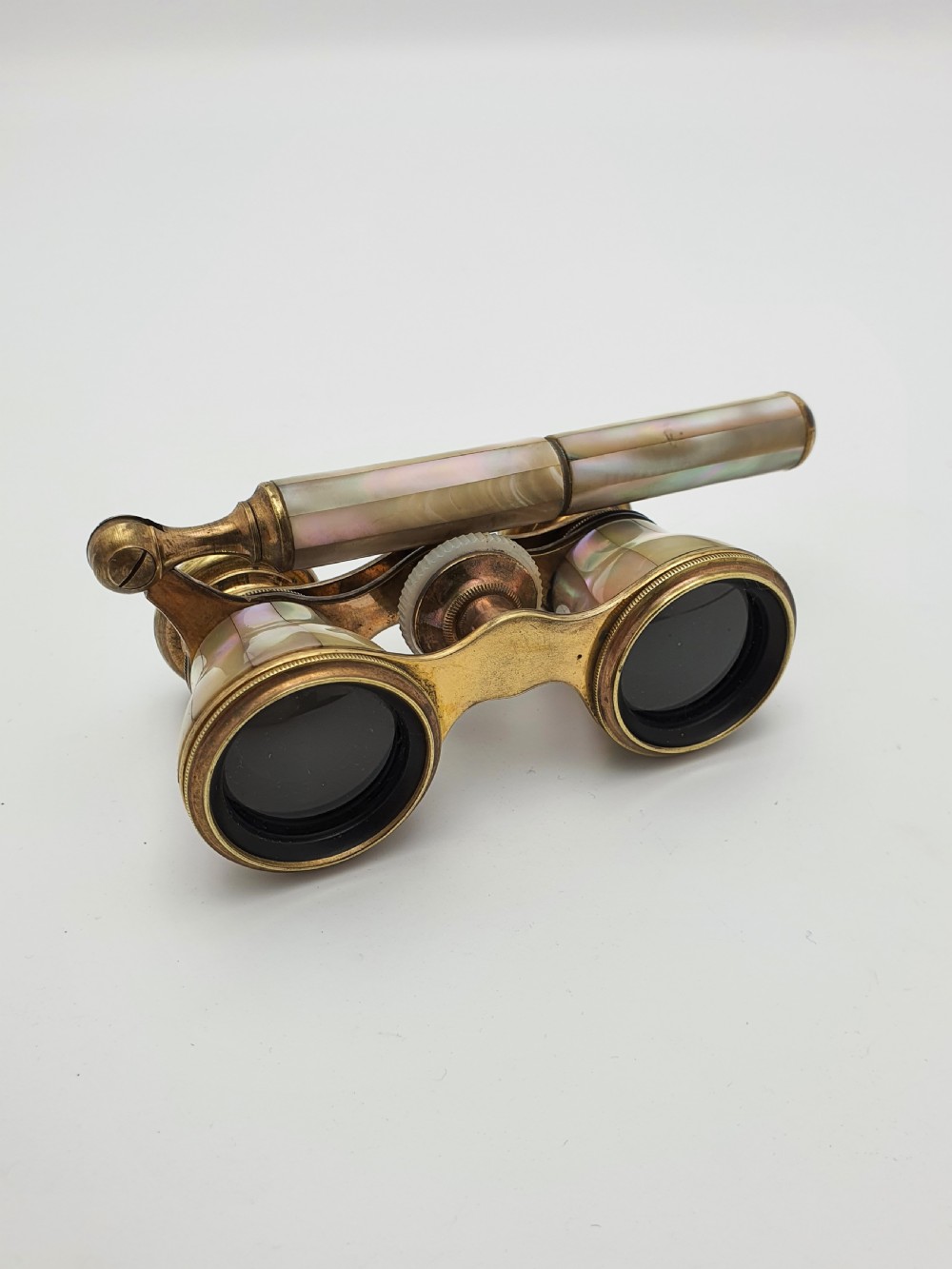 Victorian brass opera glasses featuring iridescent mother of pearl panels on the barrels and an extendable handle. View IV
