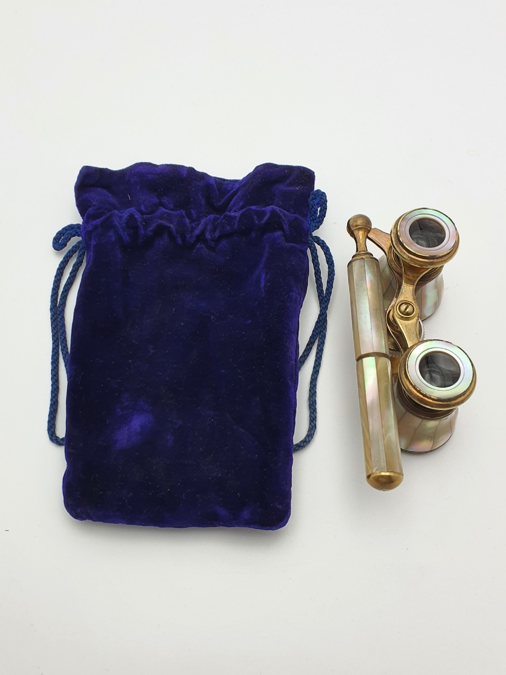 Victorian brass opera glasses featuring iridescent mother of pearl panels on the barrels and an extendable handle. View VII