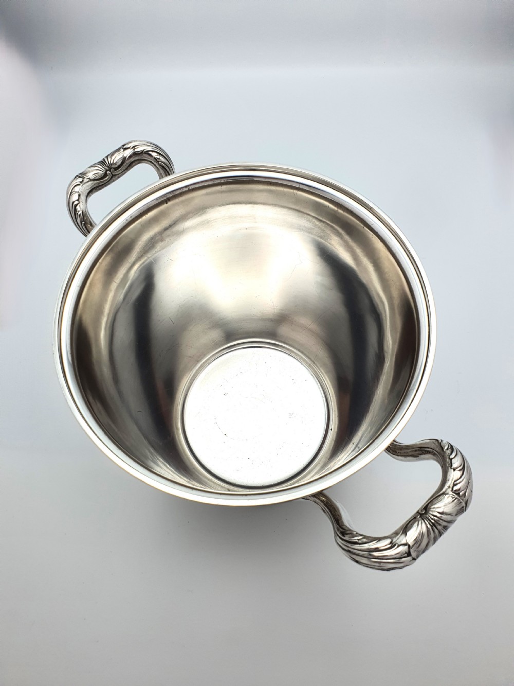 A silver-plated champagne bucket featuring twin side handles, a moulded rim, and an engraved script monogram on the front. View V