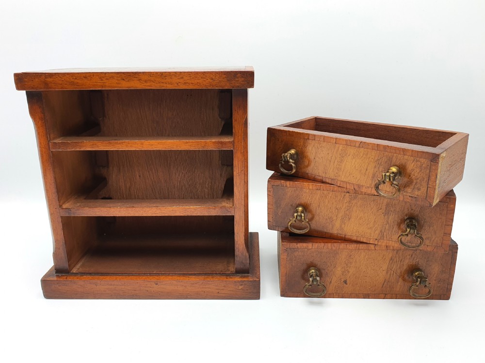 A small mahogany three-drawer miniature chest with brass drop handles and inlaid wood banding. View IX