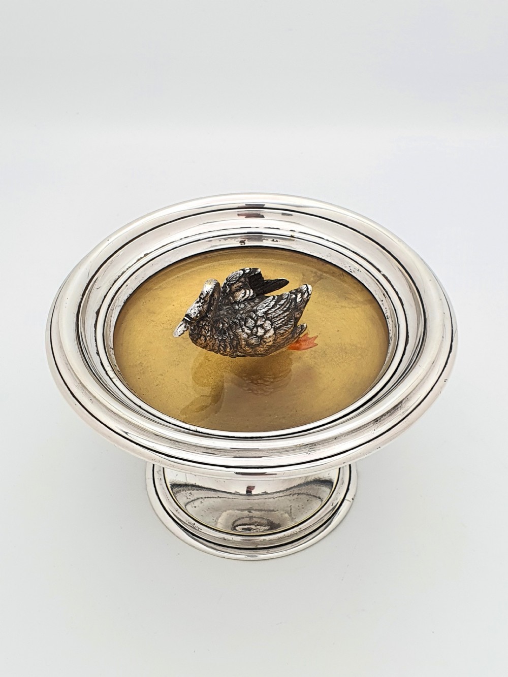 A circular silver pedestal comport featuring a central cast silver swan figure mounted inside a shallow basin. View V
