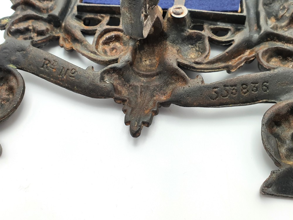 An ornate dark bronze Edwardian cast iron picture frame decorated with cherubs, miniature side columns, scrolling foliate detailings, and a green felt insert. View VI