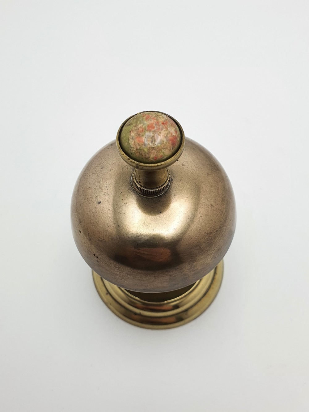 A late Victorian brass and bronze counter bell featuring a stepped circular base, dome bell, and push-button mechanism. View VI
