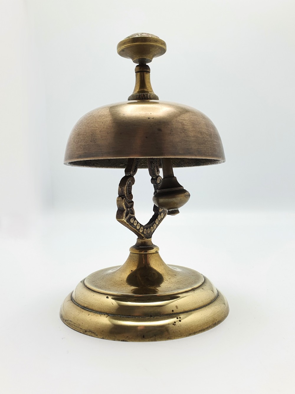 A late Victorian brass and bronze counter bell featuring a stepped circular base, dome bell, and push-button mechanism. View VII