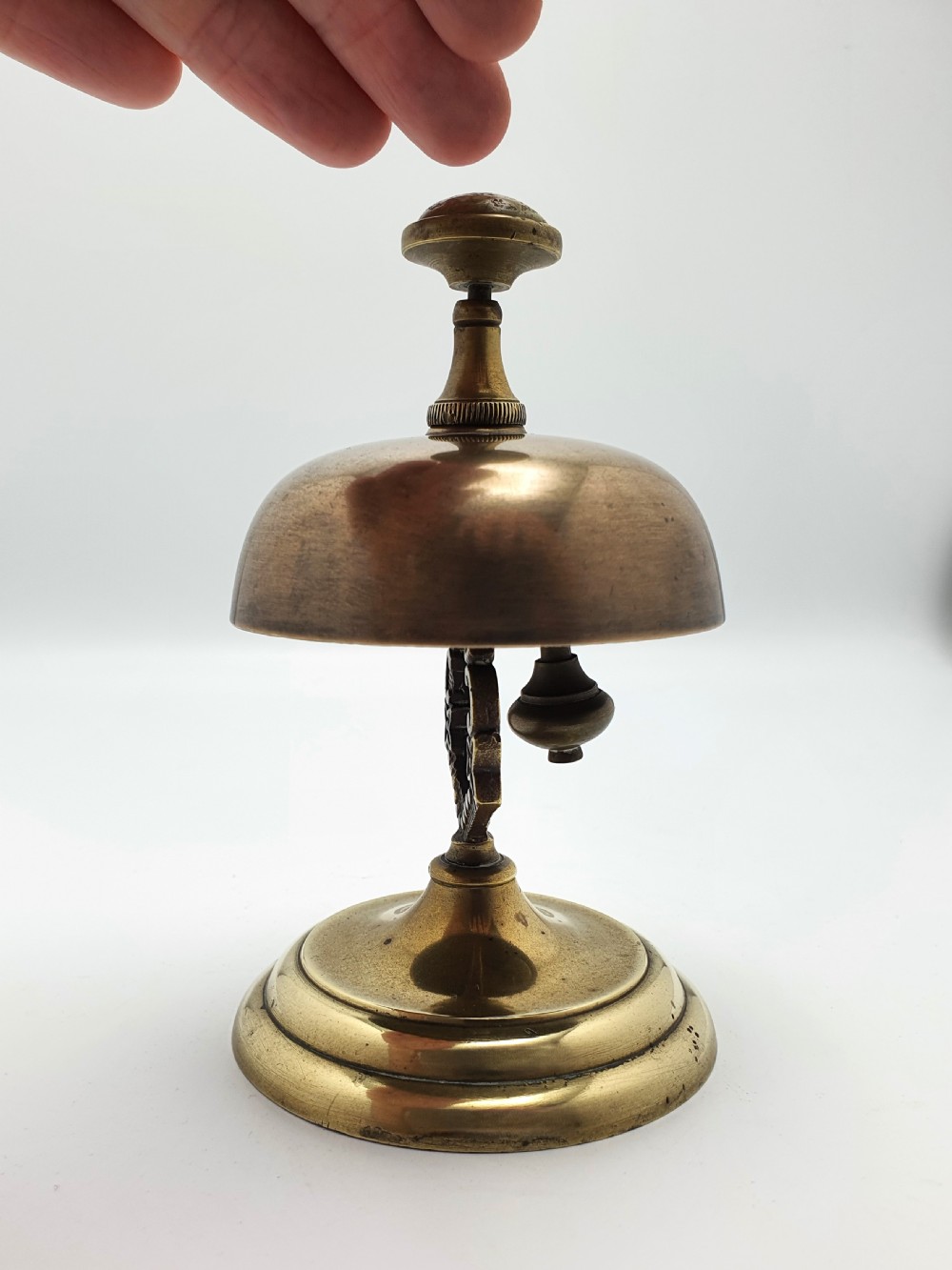 A late Victorian brass and bronze counter bell featuring a stepped circular base, dome bell, and push-button mechanism. View IX