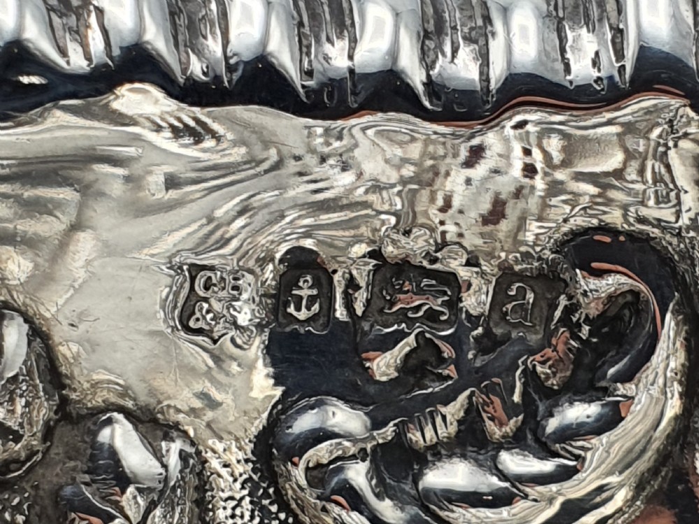 An ornate late Victorian pierced sterling silver basket featuring floral repousse ornamentation and a pedestal base. View VI