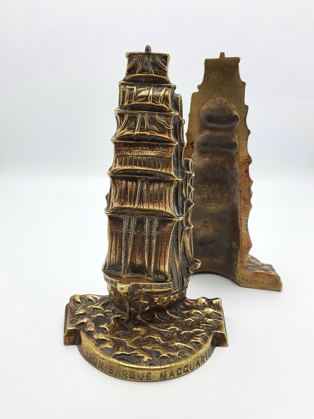 A pair of solid brass bookends featuring a relief design of a tall sailing ship on ocean waves. View IV