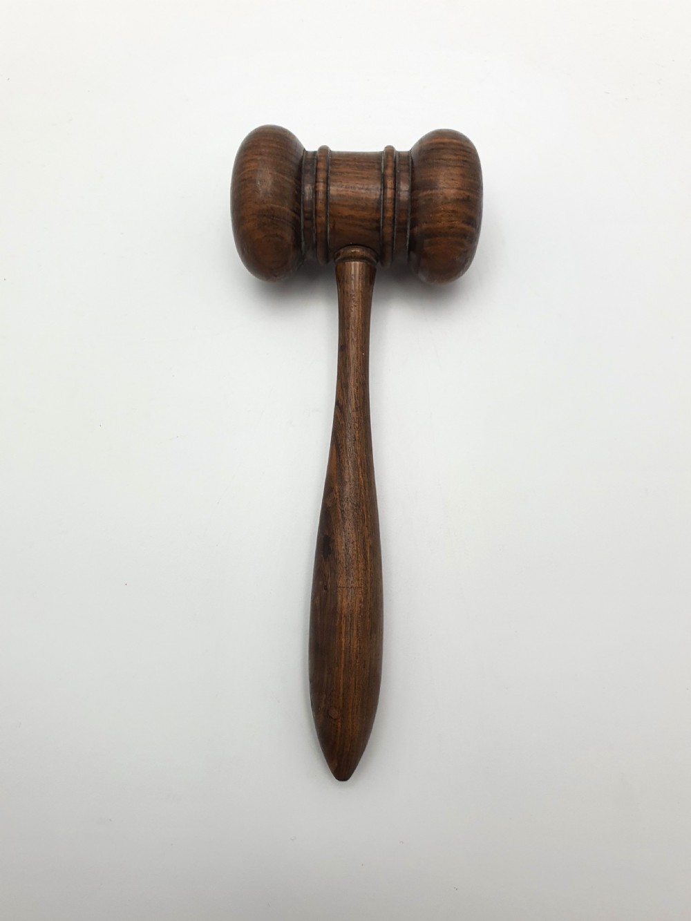 A dark turned hardwood auctioneer gavel featuring a double-ended head with moulded ring details and a tapered handle. View III