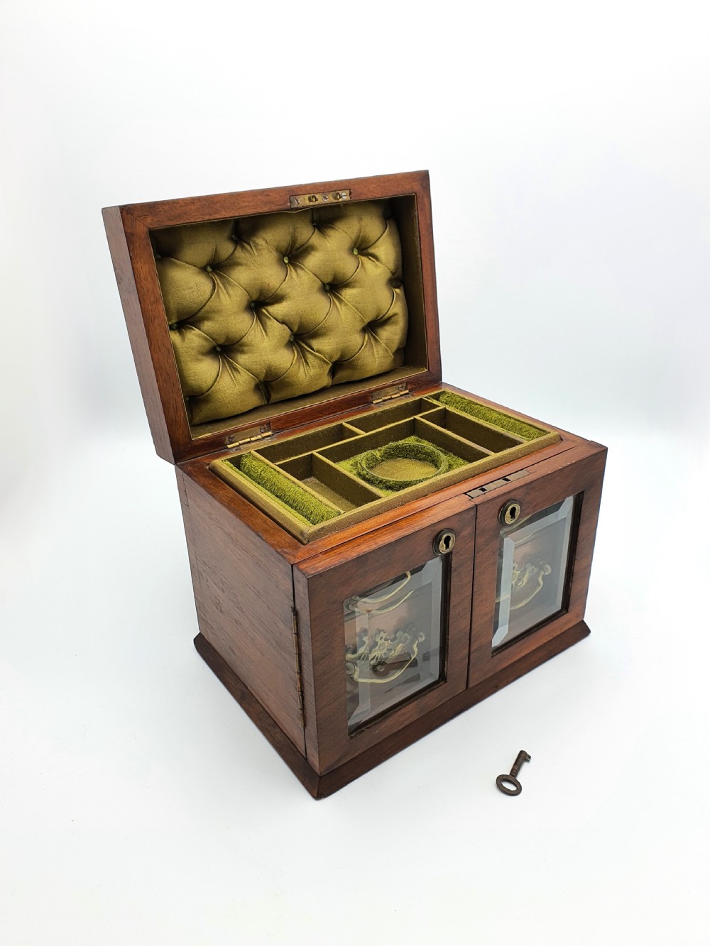 A Victorian walnut jewellery chest with open glass-panelled side doors, two pull-out drawers with brass handles, and an open lid revealing a button-tufted green velvet interior. View IV