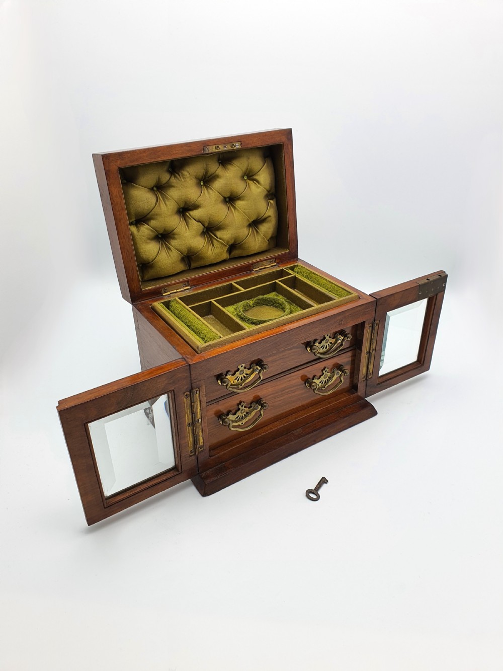A Victorian walnut jewellery chest with open glass-panelled side doors, two pull-out drawers with brass handles, and an open lid revealing a button-tufted green velvet interior. View V
