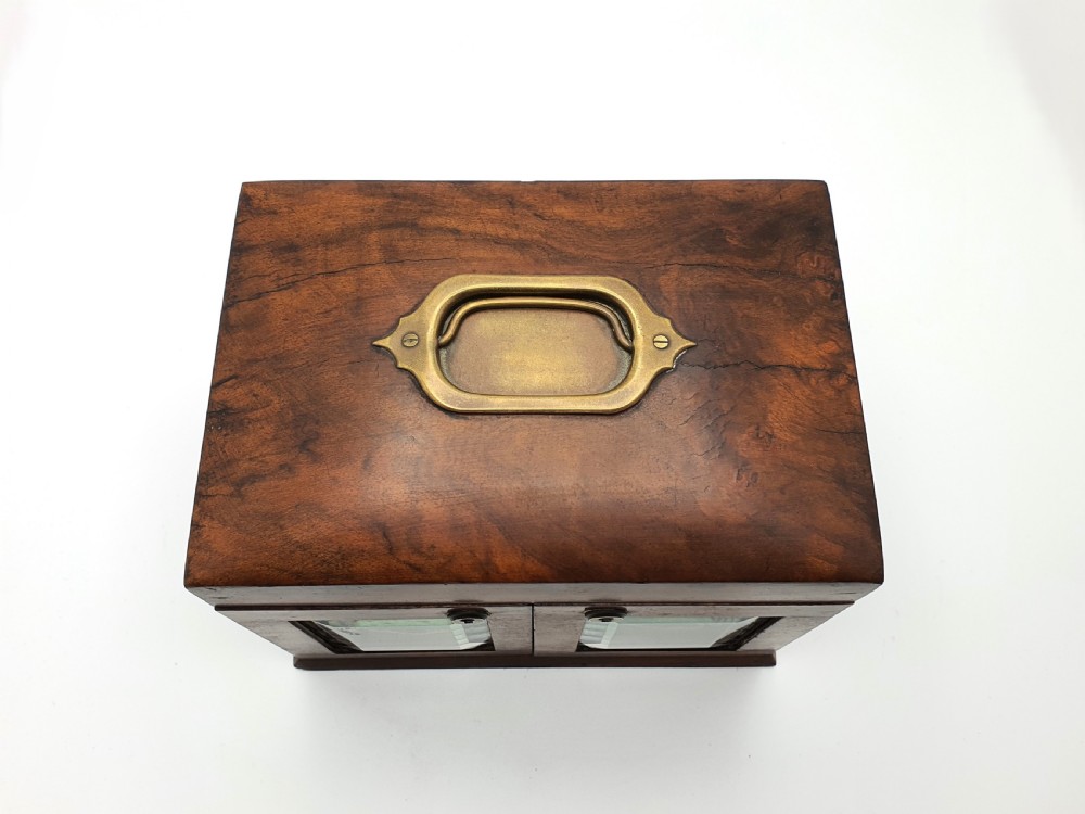 A Victorian walnut jewellery chest with open glass-panelled side doors, two pull-out drawers with brass handles, and an open lid revealing a button-tufted green velvet interior. View XI