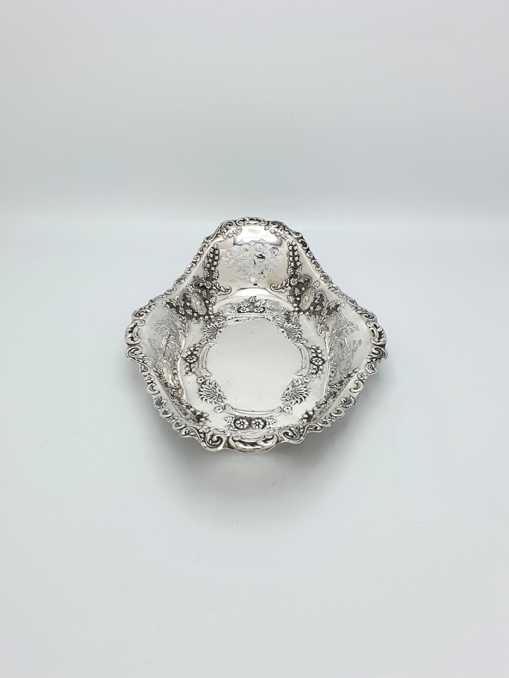 An oval Edwardian solid sterling silver serving dish featuring intricate pierced fretwork sides, scrolled borders, and relief floral decoration. View VII