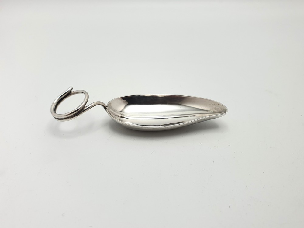 An antique sterling silver tea caddy spoon crafted in the shape of a natural leaf with a wire stem loop handle. View III