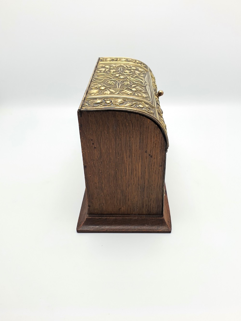 An Edwardian Art Nouveau document box featuring embossed floral brass panels over a dark timber base with a domed lid. View V
