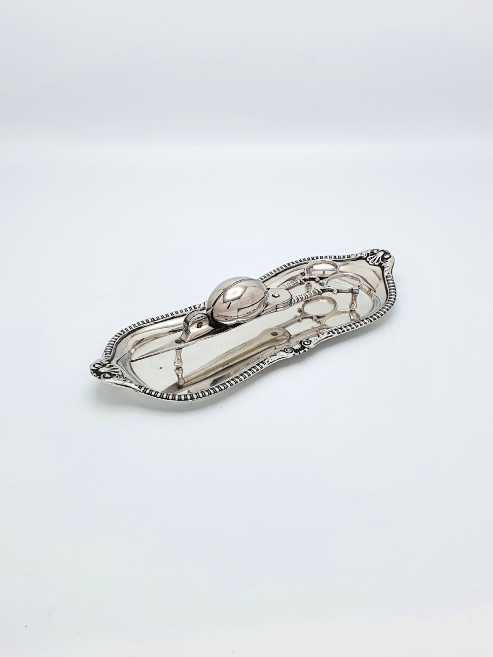 A Victorian silver-plated candle snuffer with scissor trimmers resting on an elongated tray with gadrooned borders. View II