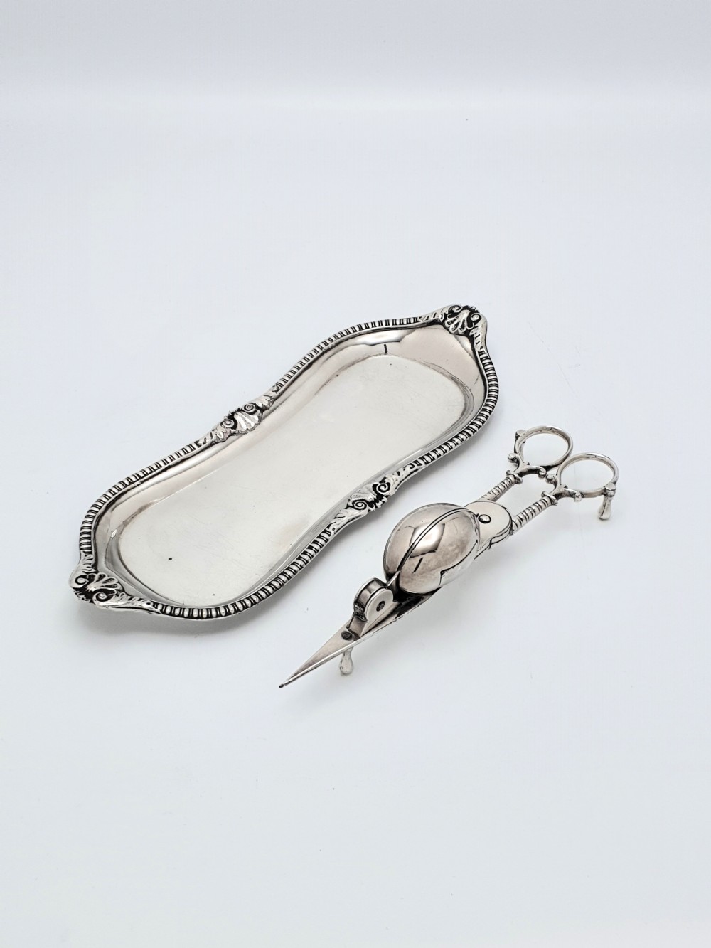 A Victorian silver-plated candle snuffer with scissor trimmers resting on an elongated tray with gadrooned borders. View III