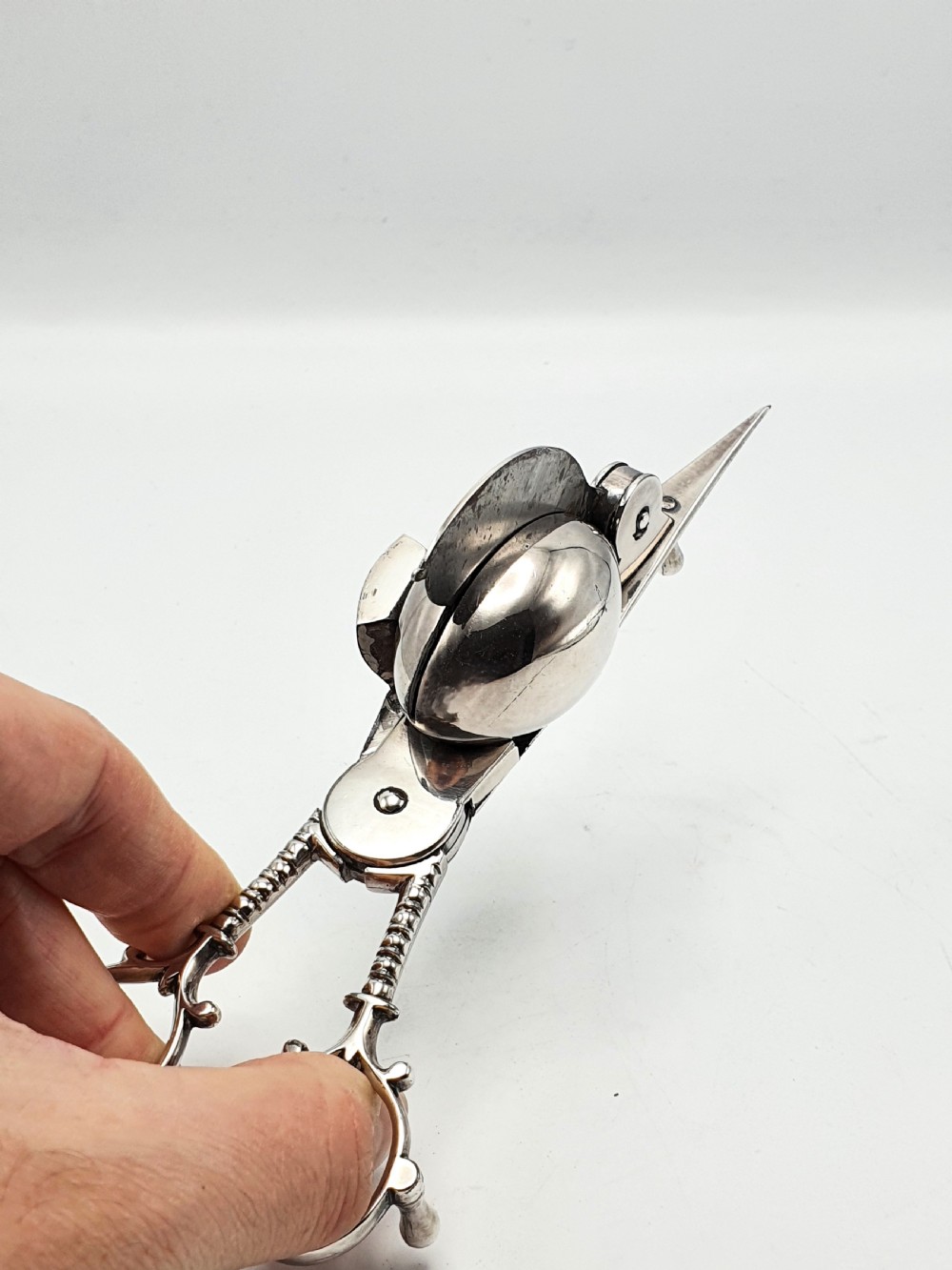 A Victorian silver-plated candle snuffer with scissor trimmers resting on an elongated tray with gadrooned borders. View VI