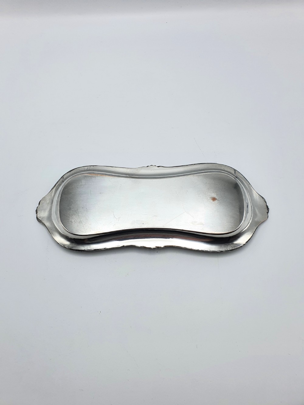 A Victorian silver-plated candle snuffer with scissor trimmers resting on an elongated tray with gadrooned borders. View IX