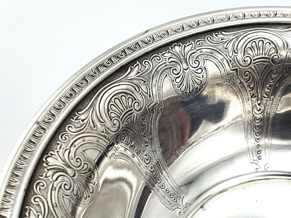A tall sterling silver comport featuring an ornate engraved interior rim, a slender central stem, and a patterned domed circular foot. View IV